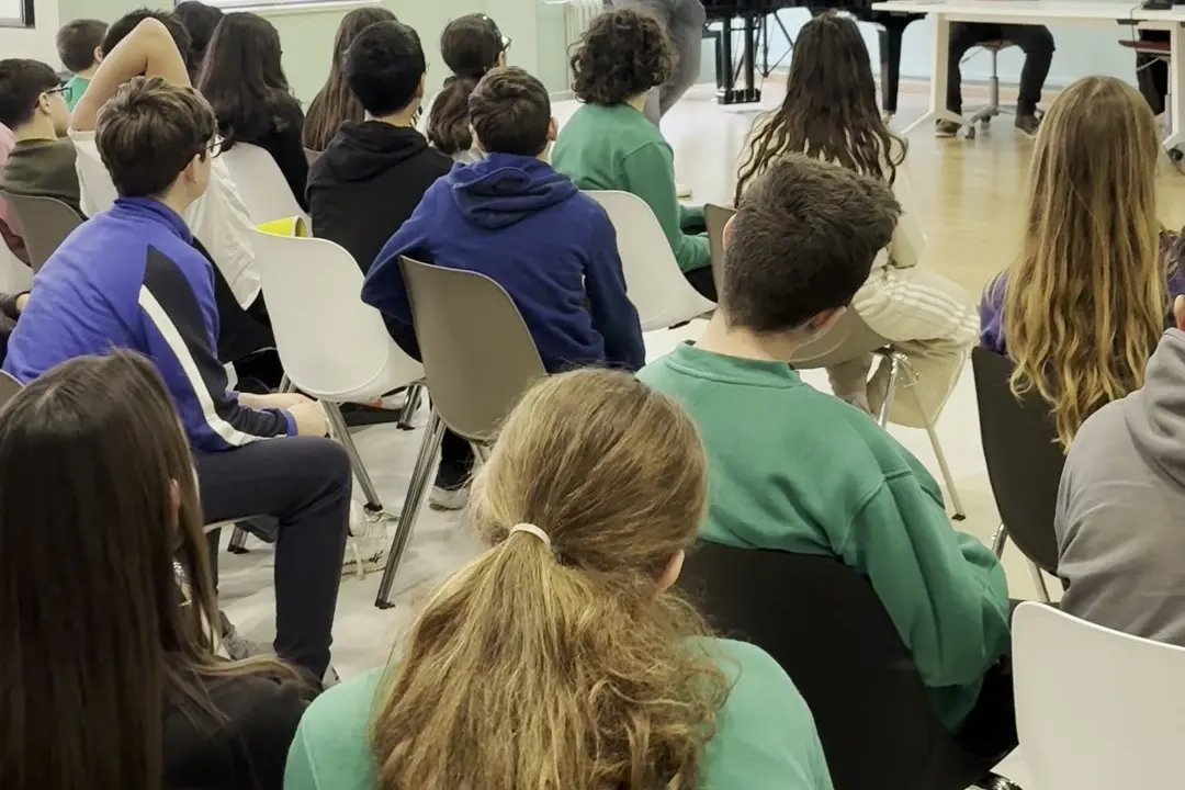 Studenti di spalle seduti in aula durante un incontro